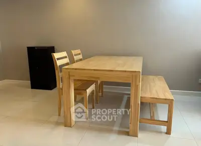 Modern dining area with wooden table, chairs, and bench on tiled floor.