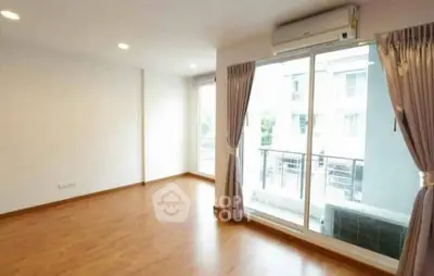 Spacious empty living room with large windows and wooden flooring