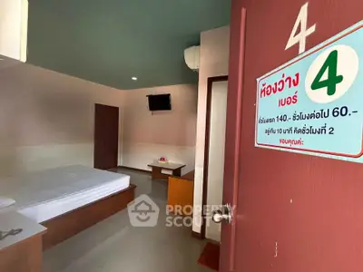 Cozy bedroom with minimalist design and wall-mounted TV, perfect for a comfortable stay.