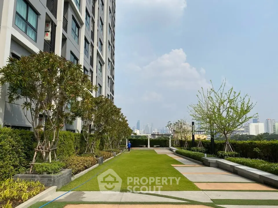 Modern apartment building with lush garden and city skyline view