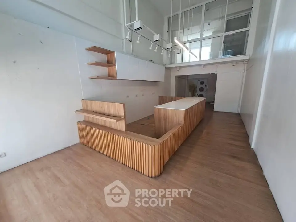 Spacious modern kitchen with wooden cabinetry and open layout in a bright, airy apartment.
