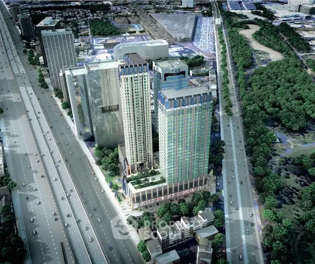 Aerial view of modern high-rise buildings in urban setting with lush greenery and highway access.
