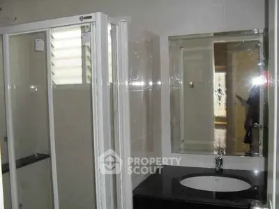Modern bathroom with glass shower and sleek vanity mirror