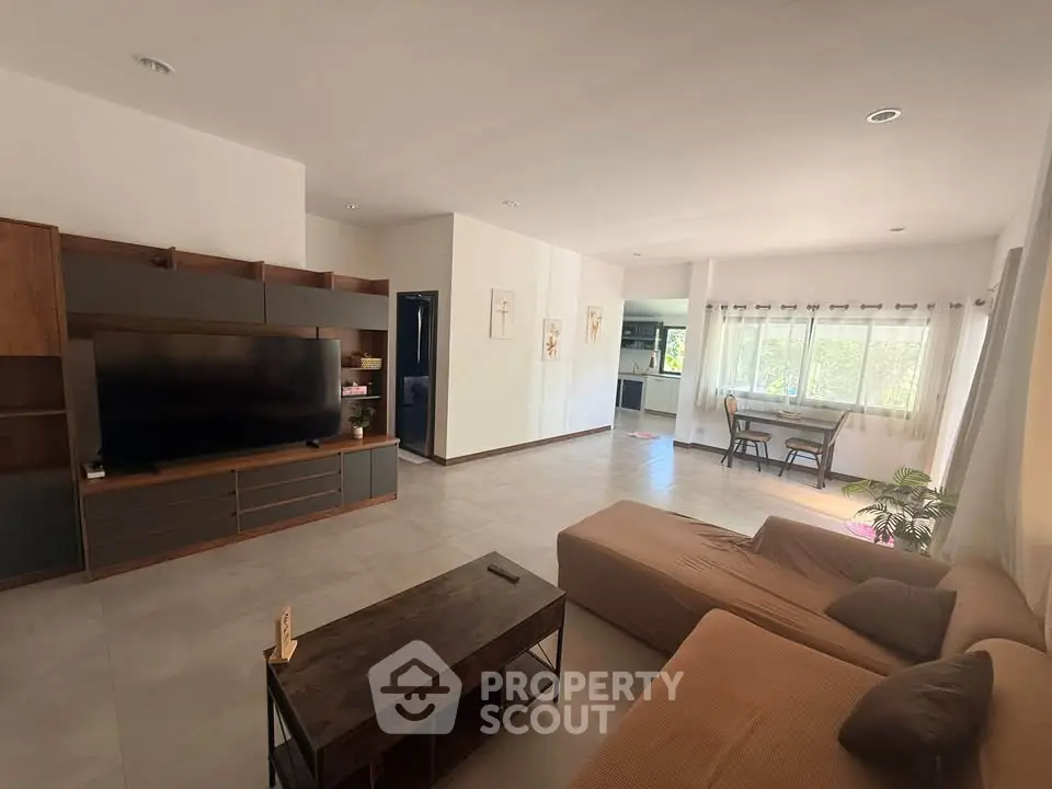 Spacious modern living room with large windows and stylish furniture, perfect for relaxation and entertainment.