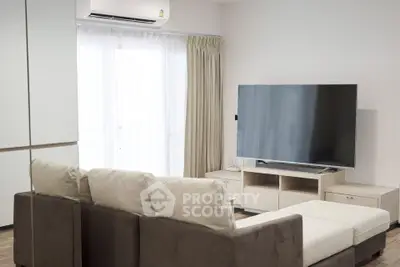 Modern living room with large TV and comfortable sofa in bright apartment