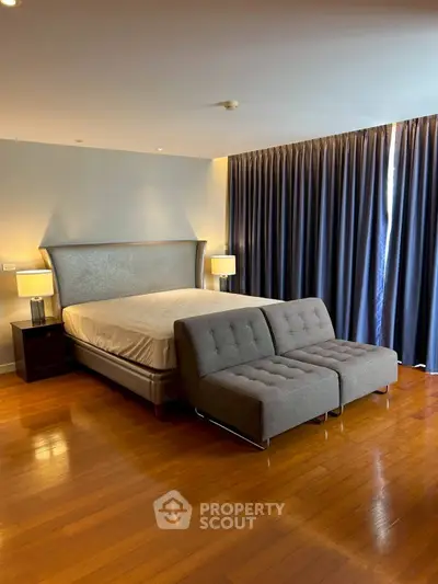 Spacious bedroom with elegant bed and modern seating area