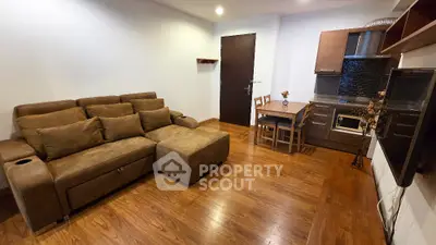 Modern living room with cozy brown sofa and compact kitchen area