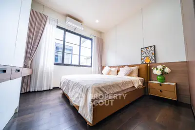 Spacious bedroom with modern decor and large window for natural light.