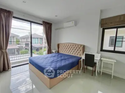 Spacious bedroom with large window and modern furnishings in a bright home