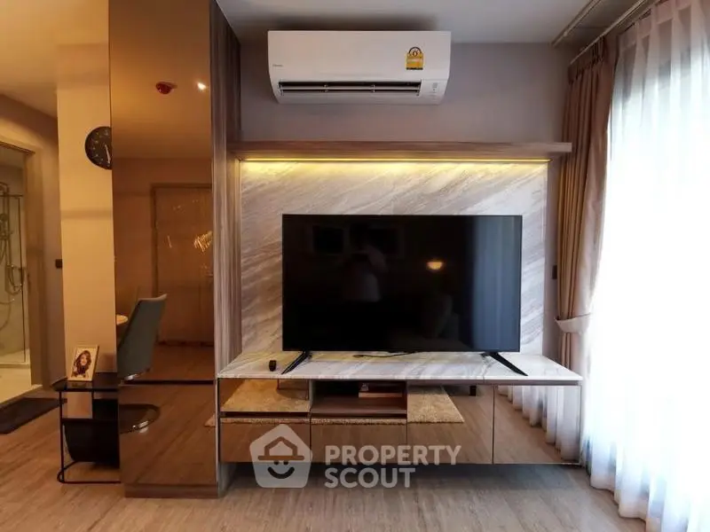 Modern living room with sleek TV unit and air conditioning, featuring elegant lighting and floor-to-ceiling curtains.