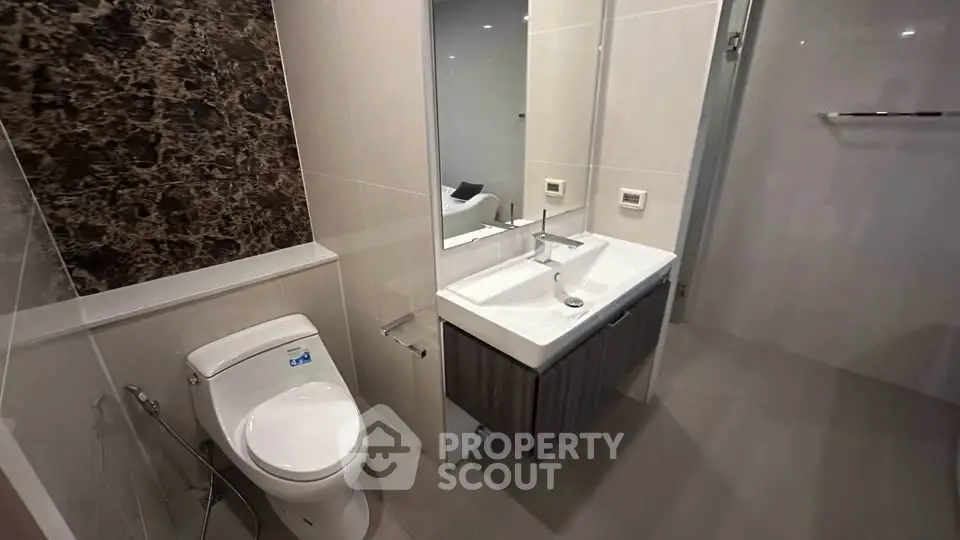 Modern bathroom with sleek fixtures and elegant marble accent wall