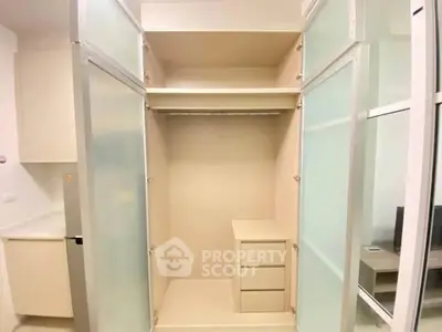Spacious modern closet with sliding doors and built-in drawers in a stylish apartment.