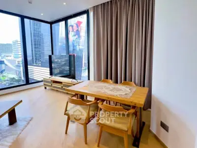 Modern living room with floor-to-ceiling windows and city view, featuring a cozy dining area.