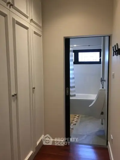 Elegant hallway leading to a modern bathroom with stylish fixtures.