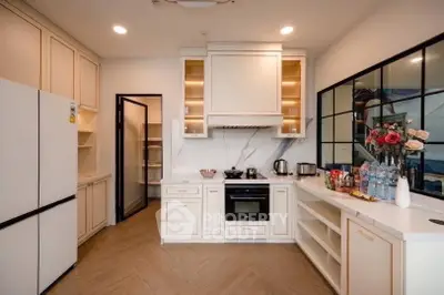 Elegant kitchen with modern appliances and open layout, featuring sleek cabinetry and stylish decor.