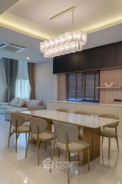 Elegant dining area with modern chandelier and stylish furniture in a contemporary open-plan living space.