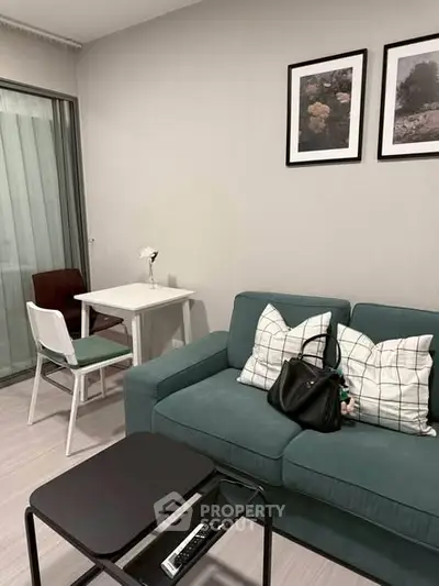 Modern living room with teal sofa, stylish decor, and cozy dining area in a chic apartment.