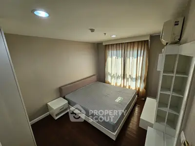 Cozy bedroom with natural light and modern furnishings in a stylish apartment.