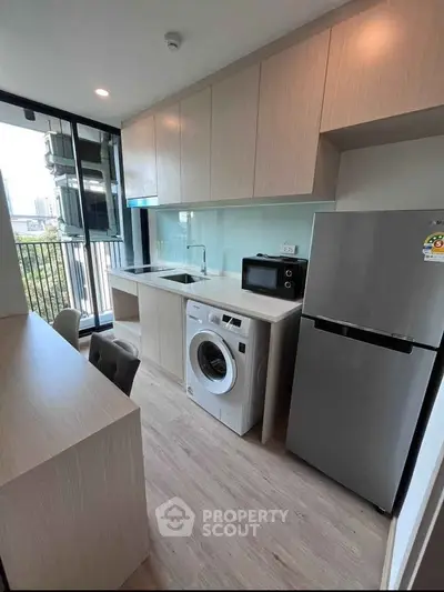 Modern kitchen with sleek appliances and balcony view in a stylish apartment