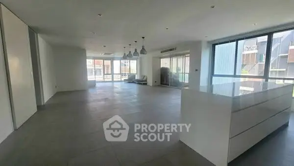 Spacious modern living room with open layout and large windows for natural light.