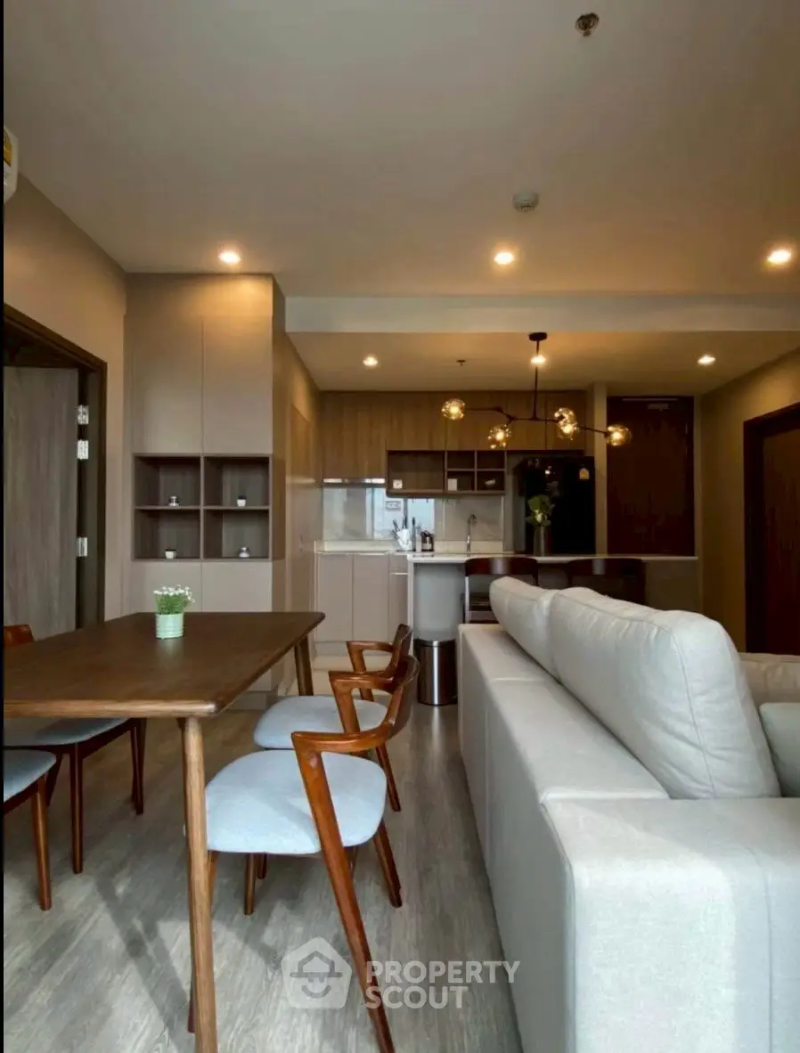 Modern open-plan living room with stylish furniture and kitchen in a cozy apartment.