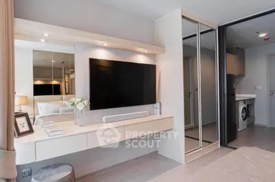 Modern bedroom with sleek design, mirrored closet, and wall-mounted TV for luxurious living.