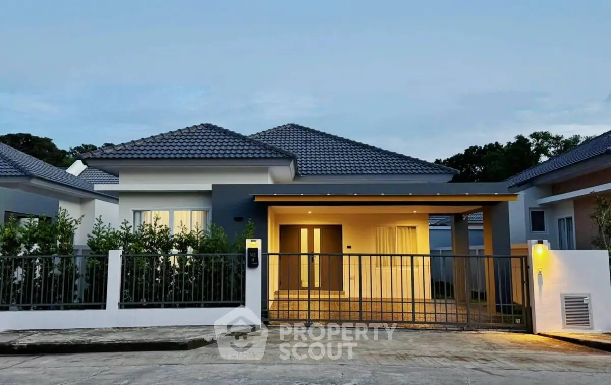 Modern single-story house with gated entrance and contemporary design.