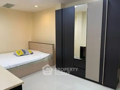 Modern bedroom with sleek wardrobe and cozy bed, perfect for urban living.