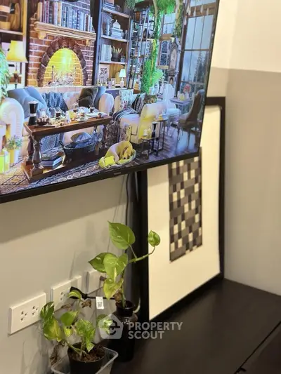 Cozy living room with stylish decor and indoor plants, featuring a large wall-mounted TV.