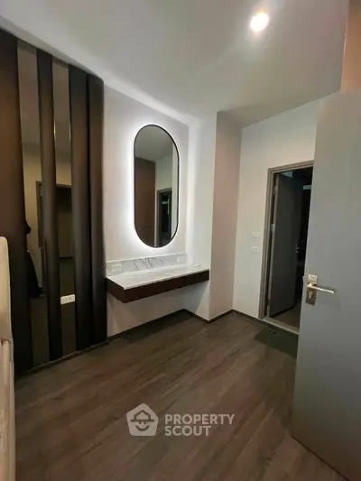 Modern interior with sleek design and elegant lighting, featuring a stylish mirror and wooden flooring.