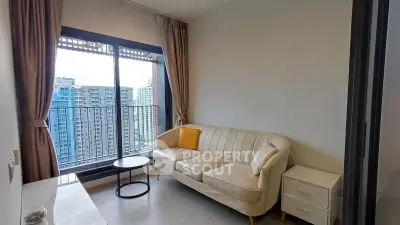 Modern living room with cozy sofa and city view balcony in high-rise apartment.