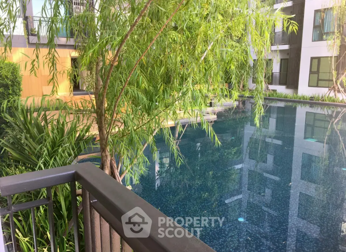 Luxurious residential pool area with lush greenery and modern architecture.