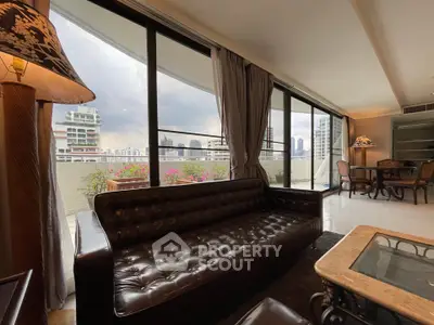 Spacious living room with leather sofa and city view balcony in luxury apartment