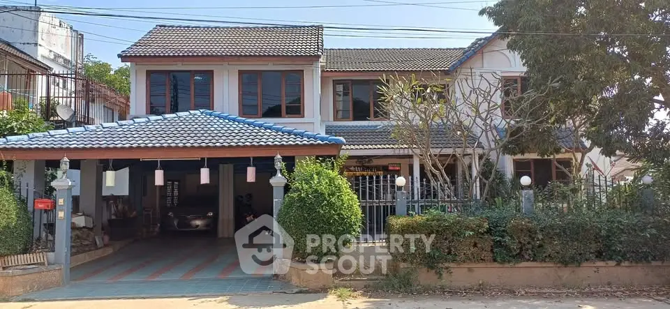 Charming two-story house with tiled roof and spacious driveway in a serene neighborhood.