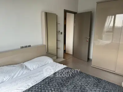 Modern bedroom with sleek furniture and neutral tones, featuring a comfortable bed and stylish wardrobe.