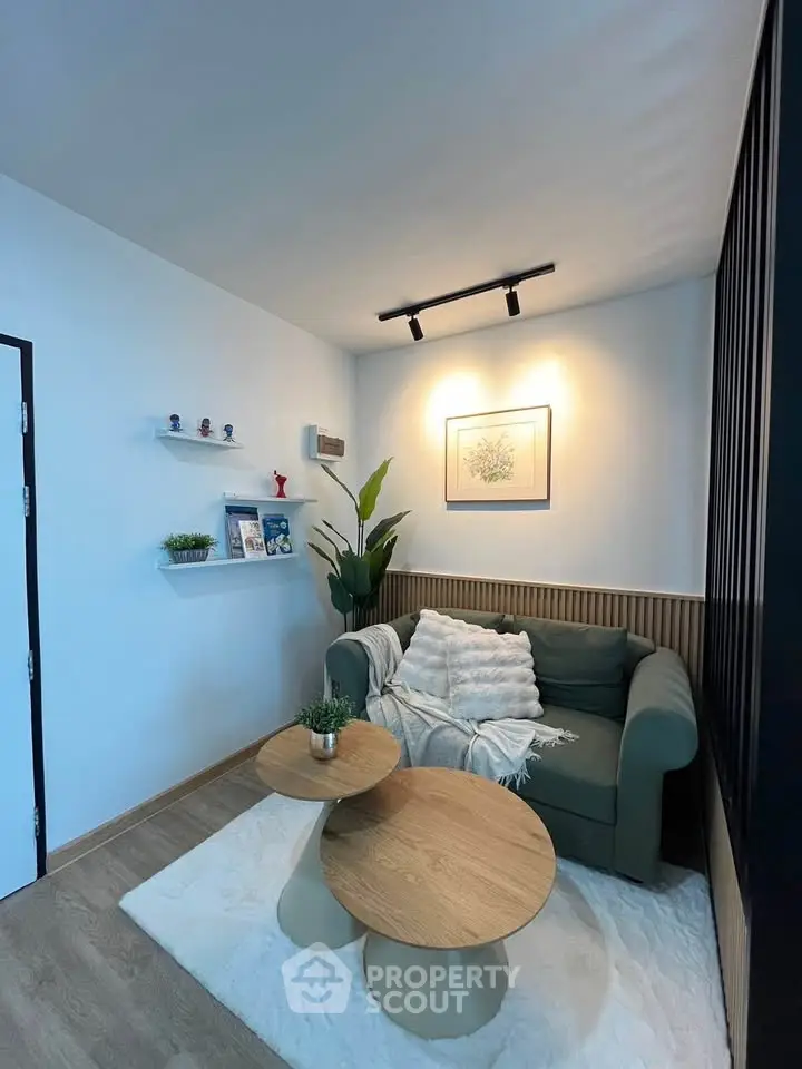 Cozy living room with modern decor, featuring a stylish sofa, wooden coffee tables, and elegant wall art.