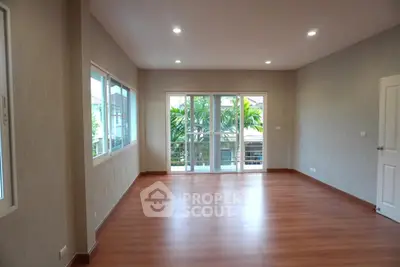 Spacious empty living room with large windows and wooden flooring