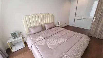 Luxurious bedroom with elegant decor and plush bedding in modern apartment.