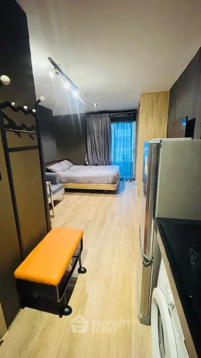 Modern studio apartment with stylish decor and natural light, featuring a cozy bed and sleek appliances.