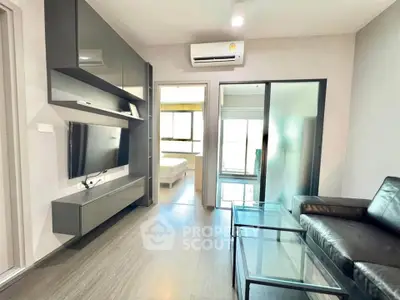Modern living room with sleek furniture and glass coffee table, leading to a bright bedroom.