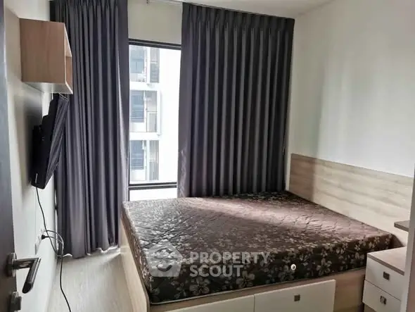 Modern bedroom with large window and stylish curtains in a contemporary apartment.