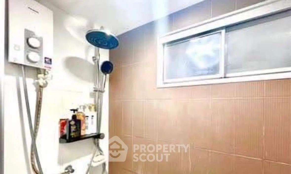 Modern bathroom with shower and window, featuring sleek design and natural light.