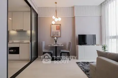 Modern living room with open kitchen, stylish decor, and natural light.