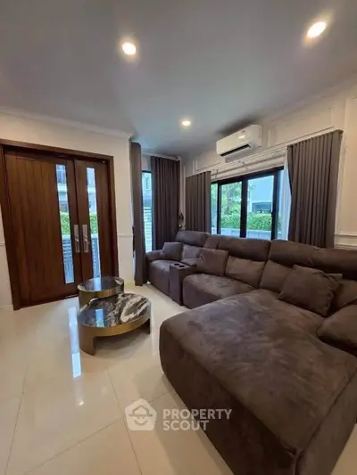 Spacious living room with modern sofa and large windows in a stylish home.