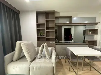 Modern living room with stylish shelving and dining area in a contemporary apartment.