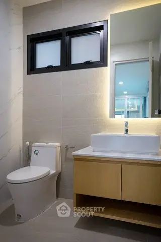 Modern bathroom with sleek fixtures and stylish vanity in a contemporary home.