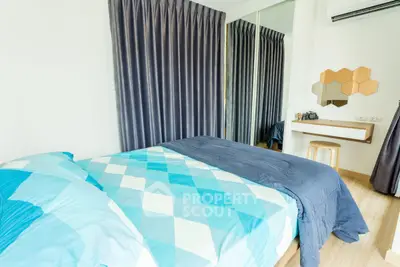 Modern bedroom with stylish decor and large mirror reflecting natural light