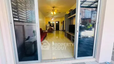 Spacious living room with sliding glass doors and ceiling fans, perfect for family gatherings.