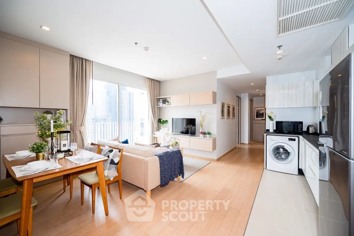 Modern open-plan living room and kitchen with stylish decor and city view.