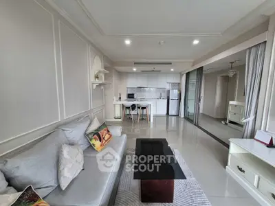 Modern living room with open kitchen, sleek furniture, and elegant decor